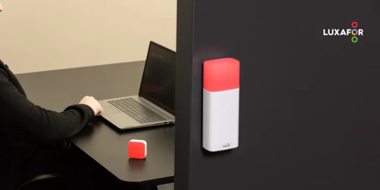 Cutting-edge productivity tools for the modern workspace 68 A red busy light for office desk glowing next to a laptop on an meeting room desk, with a red LED do not disturb indicator outside the meeting-room.